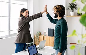 Coworkers in an office giving high-fives