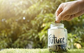 Someone place coins in a savings jar